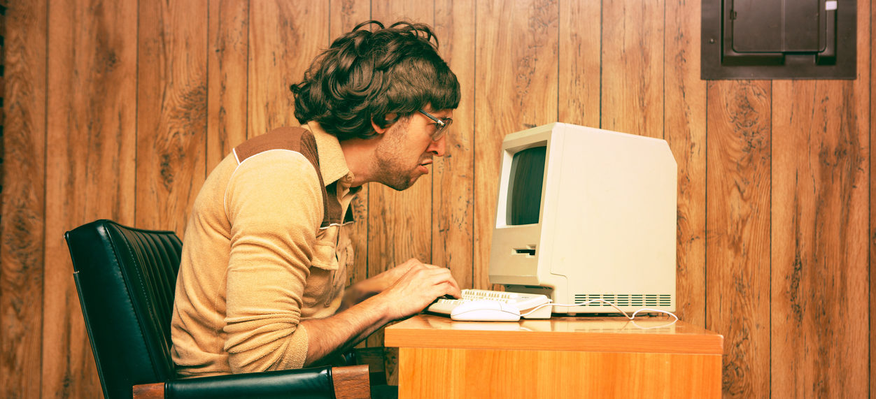 Satirical image of man working at a computer in the 1970s