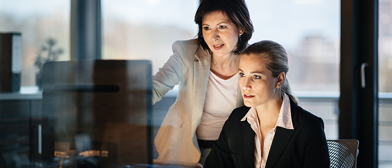 Two businesswomen looking at a computer screen